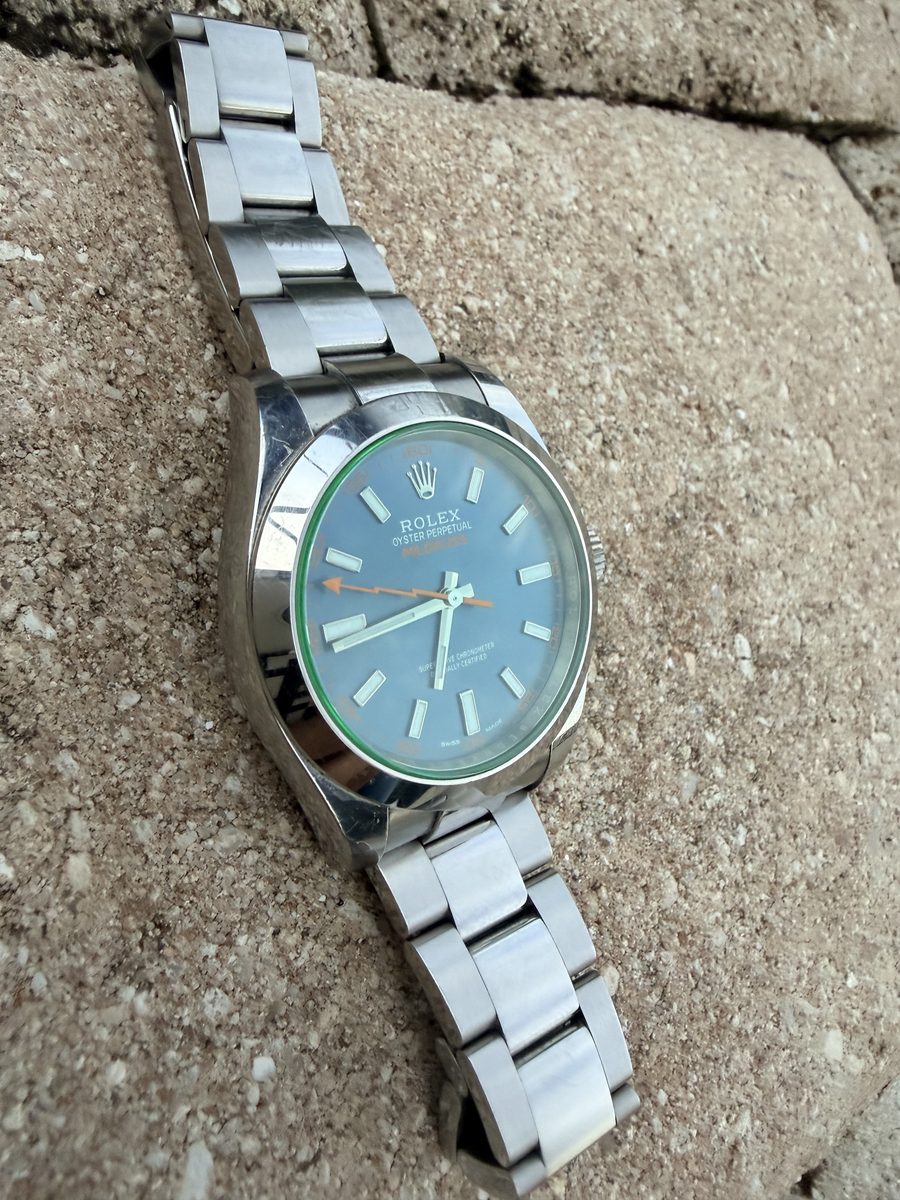 The same watch at a low angle, the green tint of the crystal showing at its edge